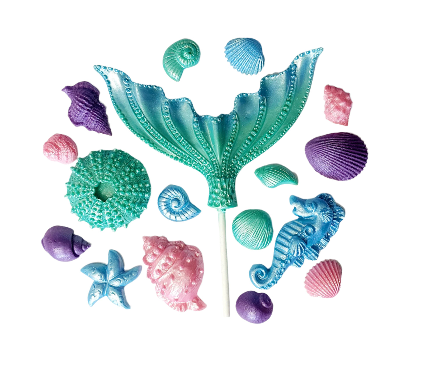 A set of edible chocolate candy cake decorations themed with a mermaid tail and various shells in shades of aqua, blue, and purple.