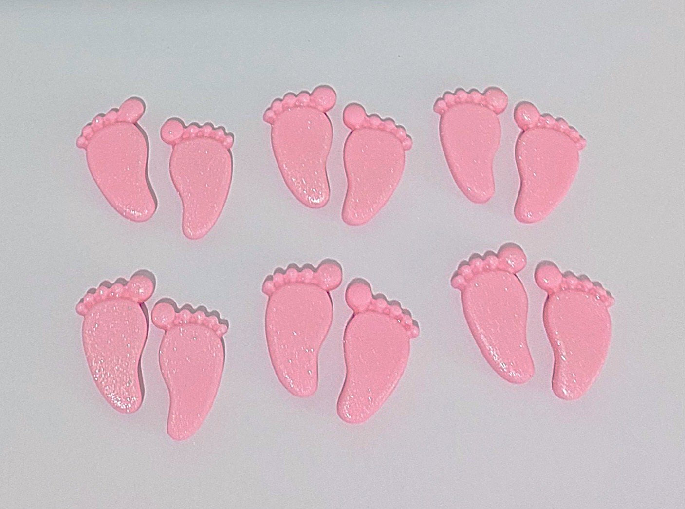 Pink baby feet, edible fondant cake decorations.