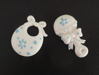 Baby rattle and bib in white and blue. Edible fondant icing cake decorations