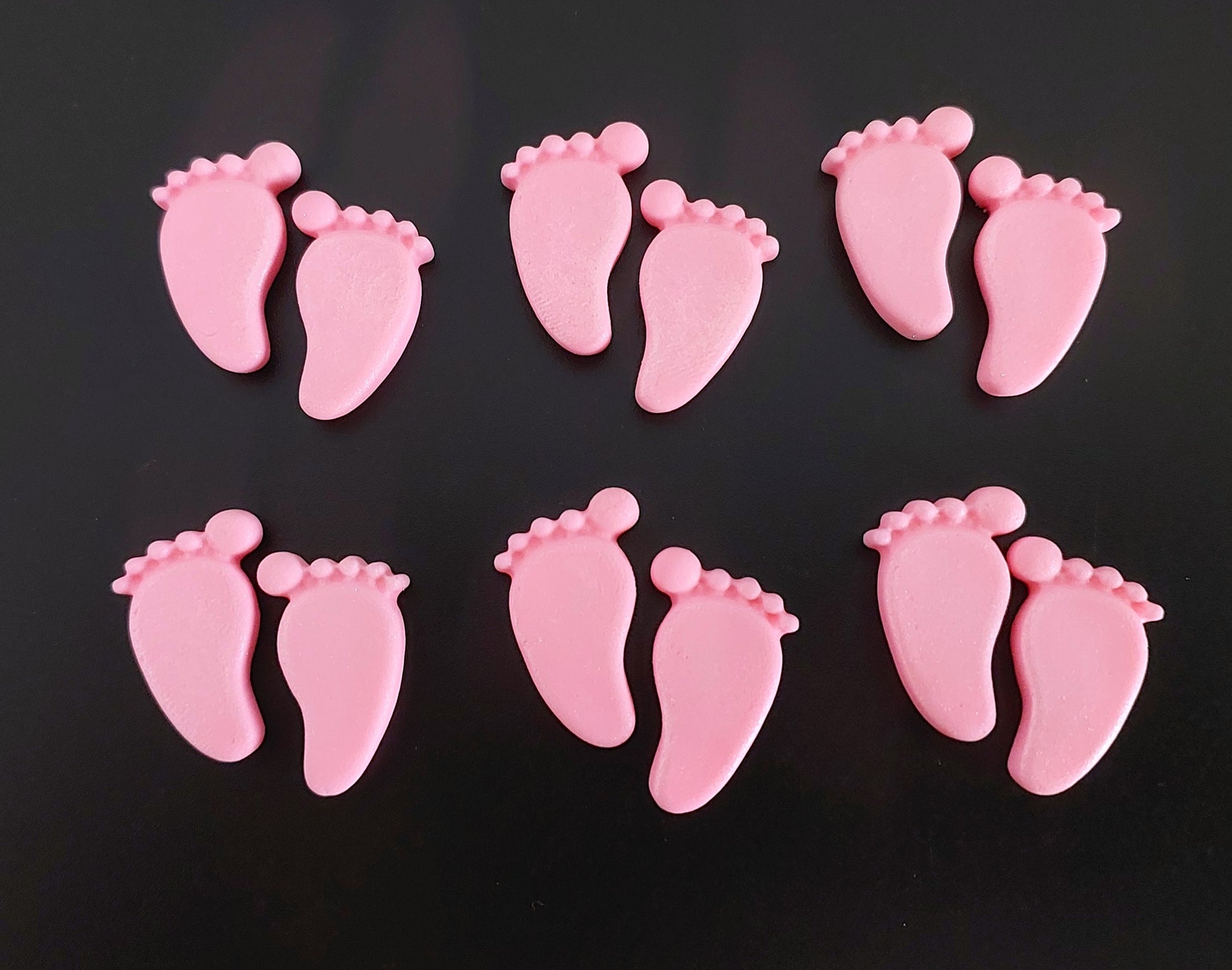 Pink baby feet, edible fondant cake decorations.