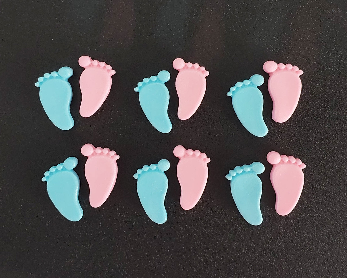 Pink and blue baby feet, edible fondant cake decorations.