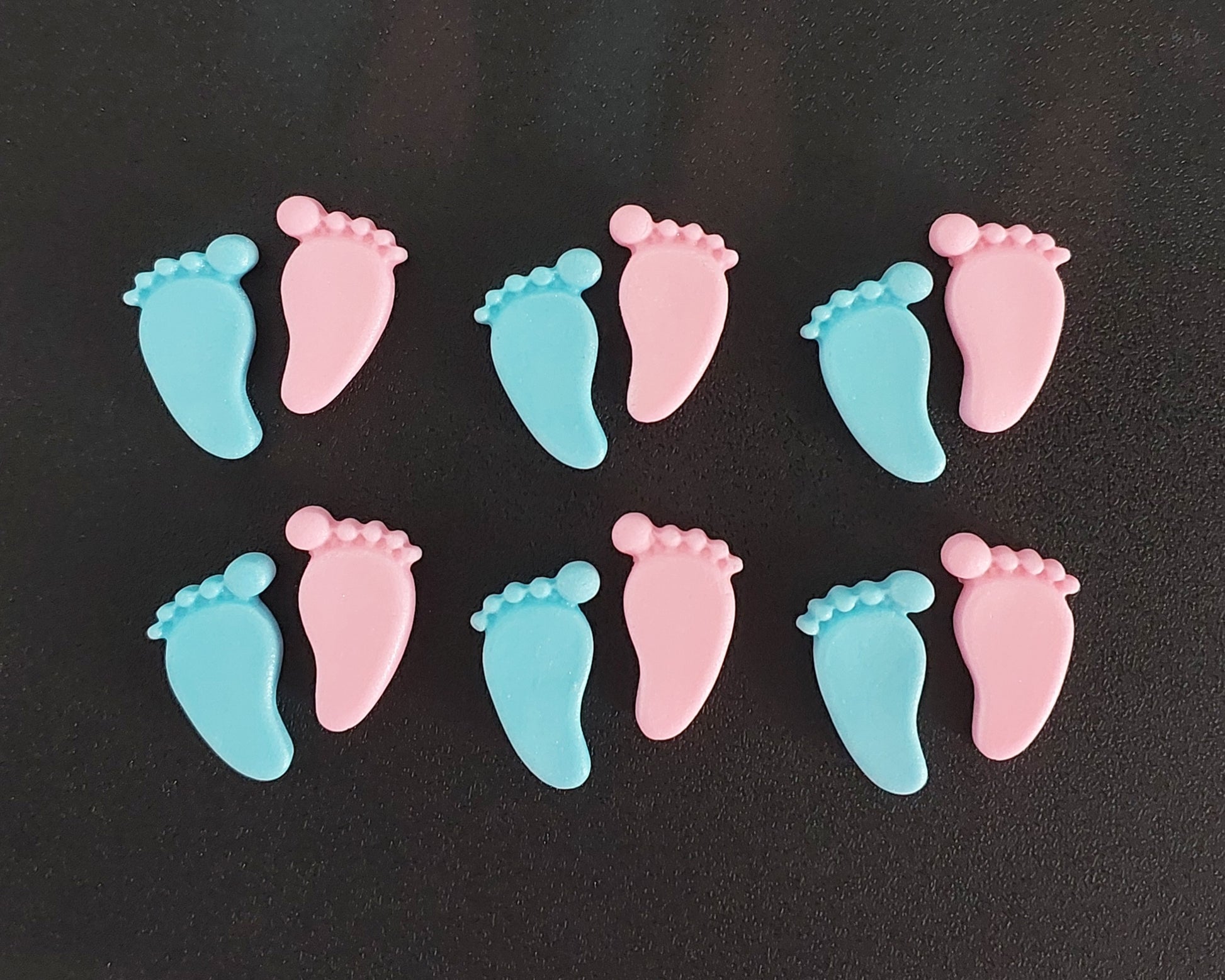 Pink and blue baby feet, edible fondant cake decorations.