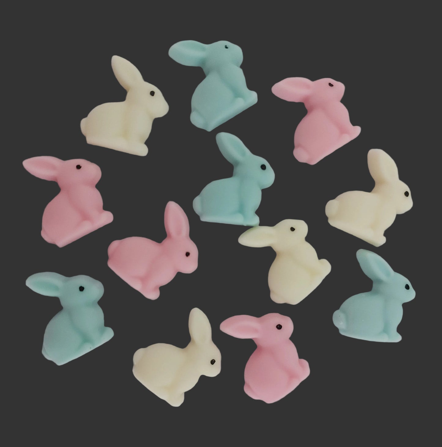 Twelve pastel-colored bunny figurines, edible chocolate cake decorations